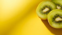 Fresh kiwi fruit slices on vibrant yellow background with copy space for healthy eating and nutrition concepts.