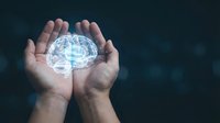 Human hands holding glowing digital brain hologram representing artificial intelligence, mental health, neuroscience and cognitive technology concepts.