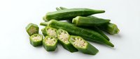 Fresh green okra pods whole and sliced showing seeds on white background. Healthy organic vegetable for cooking and nutrition isolated for design use.
