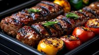 Grilled sausages with herbs and roasted vegetables on barbecue grill pan for summer cooking and outdoor dining.