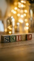 Vintage wooden blocks spelling "SKILD" arranged on wooden surface with warm golden bokeh lights in soft focus background, suitable for educational and holiday designs.