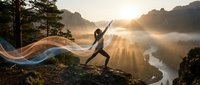 Young athletic woman practicing yoga warrior pose on mountain cliff at sunrise with flowing fabric and misty valley below. Meditation wellness concept.