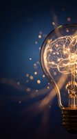 Glowing light bulb with brain filament on dark blue background with golden bokeh lights representing creativity and innovation concepts.