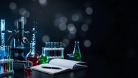 Scientific laboratory setup with colorful chemical solutions in glassware, open notebook and bokeh lights creating professional research atmosphere.
