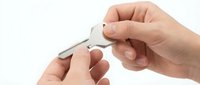 Professional manicure process with nail clippers trimming fingernails on clean white background for beauty and personal care applications.