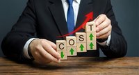 Businessman arranging wooden blocks spelling COST with green arrows and a red upward arrow, symbolizing rising expenses and financial growth.