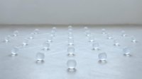 Transparent glass spheres arranged in connected network pattern on white surface, representing data connection, technology infrastructure, communication systems, and digital networking concepts for web design and tech presentations.