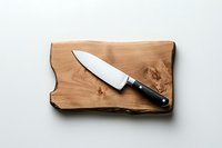 Professional chef knife on rustic wooden cutting board against white background, minimalist kitchen composition for culinary and food preparation concepts.