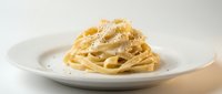 Creamy pasta carbonara with crispy guanciale, pecorino cheese, and black pepper served on white plate for restaurant menus and food blogs.