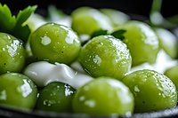 Fresh green grapes with water droplets in macro view showing juicy texture and natural moisture on smooth skin surface, selective focus creates depth effect.