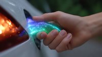 Magical glowing energy flows between hands in ethereal colors, showing mystical power transfer with vibrant blue and green light effects against dark background.
