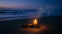 Romantic candle glowing on sandy beach at twilight with ocean waves and purple sunset sky creating peaceful evening atmosphere for meditation and relaxation.