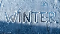 Word WINTER carved in frost on icy blue glass surface, snow texture background for seasonal greeting cards and banners.
