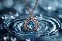 Elegant rose gold pendant with teardrop blue topaz gemstone and diamonds captured in water ripples against dark aqua background with bokeh light effects.