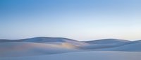 Serene winter landscape with rolling snow-covered hills under soft blue sky, creating peaceful minimalist scenery for nature and seasonal design projects.
