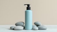 Minimalist spa composition with light blue cosmetic pump bottle and smooth zen stones on neutral background, wellness and skincare concept.