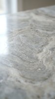 Close-up view of natural marble stone surface with elegant gray and white veining patterns and polished finish for luxury interior design projects.