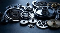 Precision mechanical gears and clockwork components arranged on dark surface for engineering and industrial manufacturing concepts.