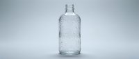 Empty glass bottle with water droplets on white background, suitable for beverage packaging mockups and product design templates.