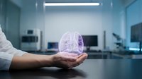 Scientist hand holding glowing purple brain hologram in modern laboratory setting, representing artificial intelligence, neural networks, and innovative technology research and development.