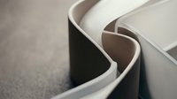 Close-up of curved white and black ceramic bowls stacked together, showcasing modern minimalist tableware design and contemporary kitchenware styling.