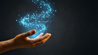 Glowing blue digital particles and light effects floating above open human hand against dark background for technology and innovation concepts.