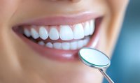 Close up of bright white healthy teeth with dental mirror showing perfect smile after professional cleaning and whitening treatment for dental care concept.