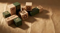 Wooden eco-friendly cubes with recycling symbols and green leaves scattered on brown paper background promoting sustainability and environmental awareness.