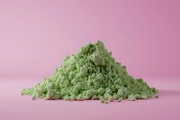 Pile of finely ground matcha green tea powder on pink background, natural organic superfood ingredient for healthy drinks and desserts.