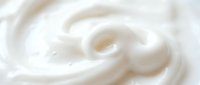 Creamy white swirl texture with smooth flowing curves creating abstract dairy or cosmetic background for food and beauty product designs.