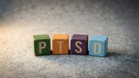 PTSD wooden blocks in different colors arranged on concrete surface for mental health awareness and psychological support concepts.