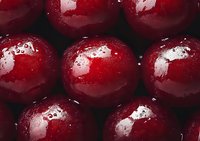 Fresh ripe cherries with water drops in macro photography showing glossy red surface and natural texture, suitable for food industry and healthy eating concepts.