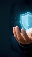 Digital security shield hologram floating above open palm representing cybersecurity protection and data safety in modern technology environment.