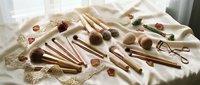Natural wooden kitchen utensils and tools arranged on cream fabric with warm sunlight creating cozy cooking preparation scene for culinary design.