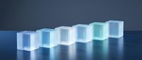 Translucent glass cubes arranged in ascending row creating modern minimalist composition with blue gradient lighting effects on reflective surface.