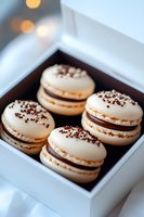 White macarons with chocolate ganache filling and sprinkles in elegant gift box. Delicate French pastries with dark chocolate decorative elements create luxurious dessert presentation.