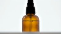 Amber glass spray bottle with black atomizer pump isolated on white background, ready for cosmetic, essential oil, or cleaning product packaging design.