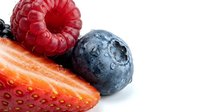 Fresh raspberries, blueberries and strawberry with water droplets on white background, isolated for food and beverage design.