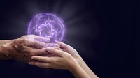 Hands holding glowing purple energy orb with swirling light patterns against dark background for spiritual healing meditation and mystical power concepts.