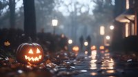 Glowing jack-o-lantern on autumn street with fallen leaves and atmospheric fog, illuminated by warm street lights at dusk.