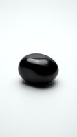 Smooth black polished stone isolated on white background for spa wellness meditation and zen relaxation concepts.