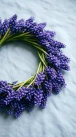 Fresh purple grape hyacinth flowers arranged in circular wreath on white marble surface for spring decoration and floral design projects.