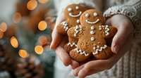Hands holding freshly baked gingerbread men cookies decorated with white icing smiles and buttons against warm bokeh lights, cozy winter holiday baking.