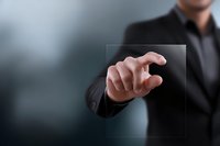 Businessman in dark suit touching transparent digital screen, demonstrating futuristic technology interface for corporate presentations.
