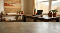 Cozy home office workspace with laptop on wooden desk, pottery decorations, macrame wall art, and natural lighting from large windows.