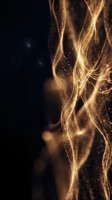 Glowing golden light waves with sparkling particles flow gracefully against a dark background, creating a luxurious abstract energy effect.