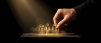 Male hand selecting glowing golden human figures from a group on dark background, representing recruitment, team selection, leadership and talent acquisition for business.