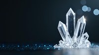 Clear quartz crystal cluster formation against dark background with blue bokeh lights, mineral specimen with translucent pointed formations emerging from base.