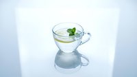 Clear glass cup filled with water and fresh mint leaves, isolated on white background for beverage, wellness, and design use.