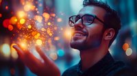 Young man with dark hair and beard, wearing glasses, smiling while holding glowing light particles in his hand against blurred bokeh background. Technology and innovation concept.